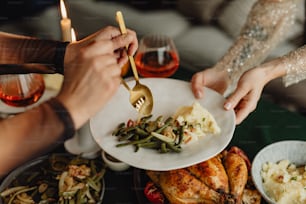 a group of people holding forks over a plate of food