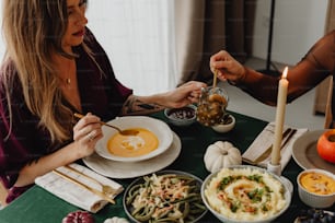 um casal de mulheres sentadas em uma mesa com pratos de comida