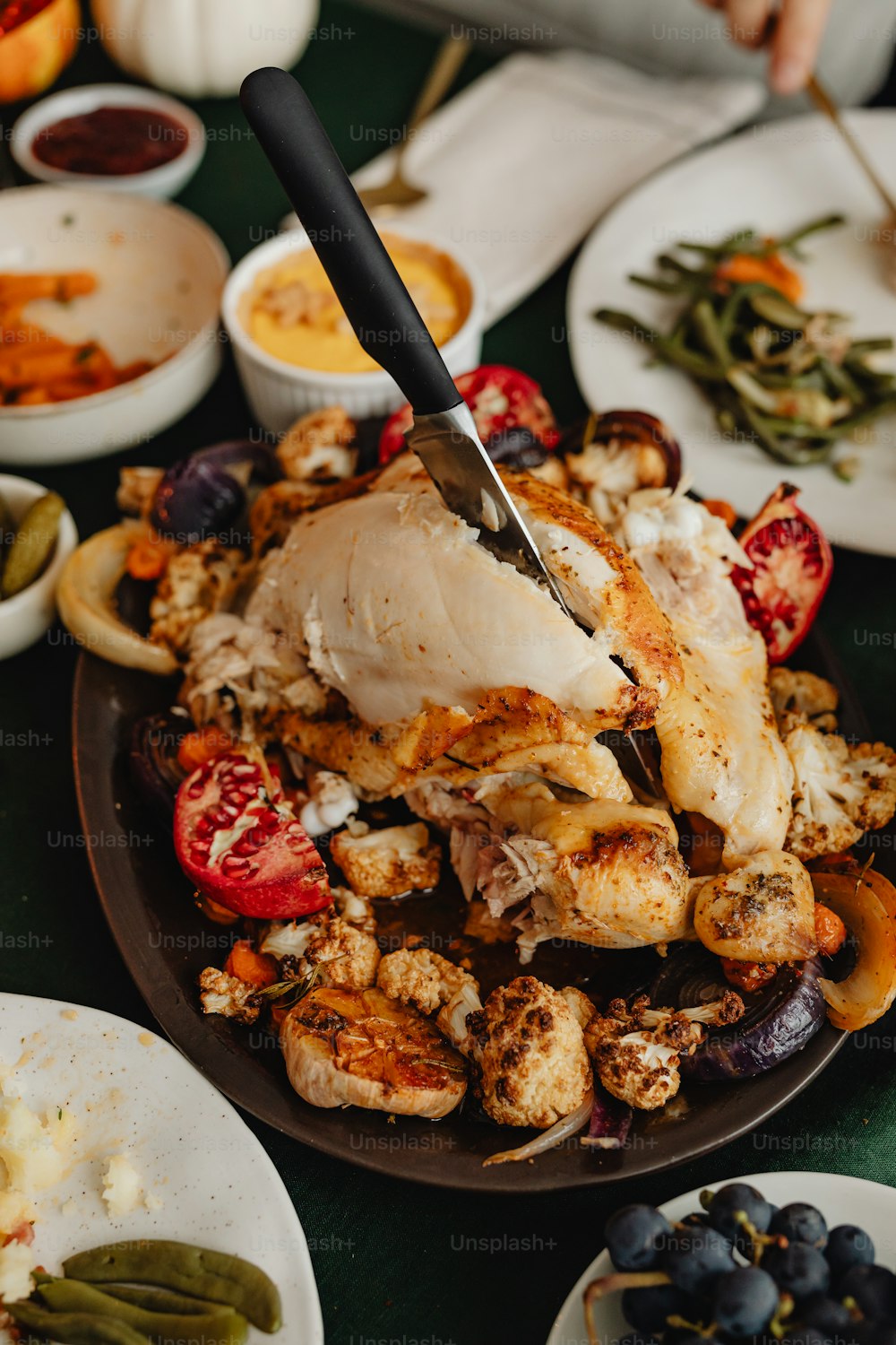 a person cutting a chicken on a plate of food