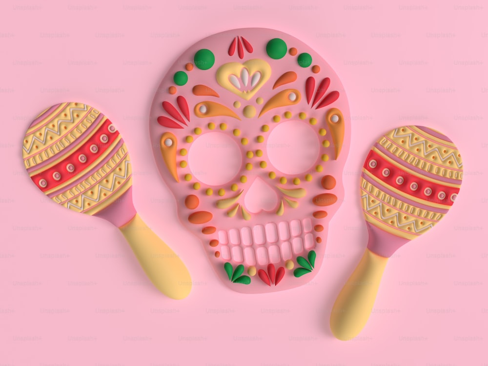 un crâne de sucre rose et deux cuillères en bois sur fond rose