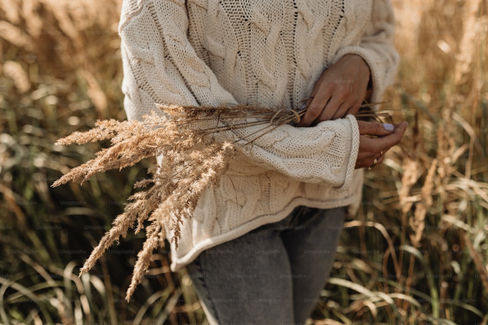 eine frau, die in einem feld mit hohem gras steht