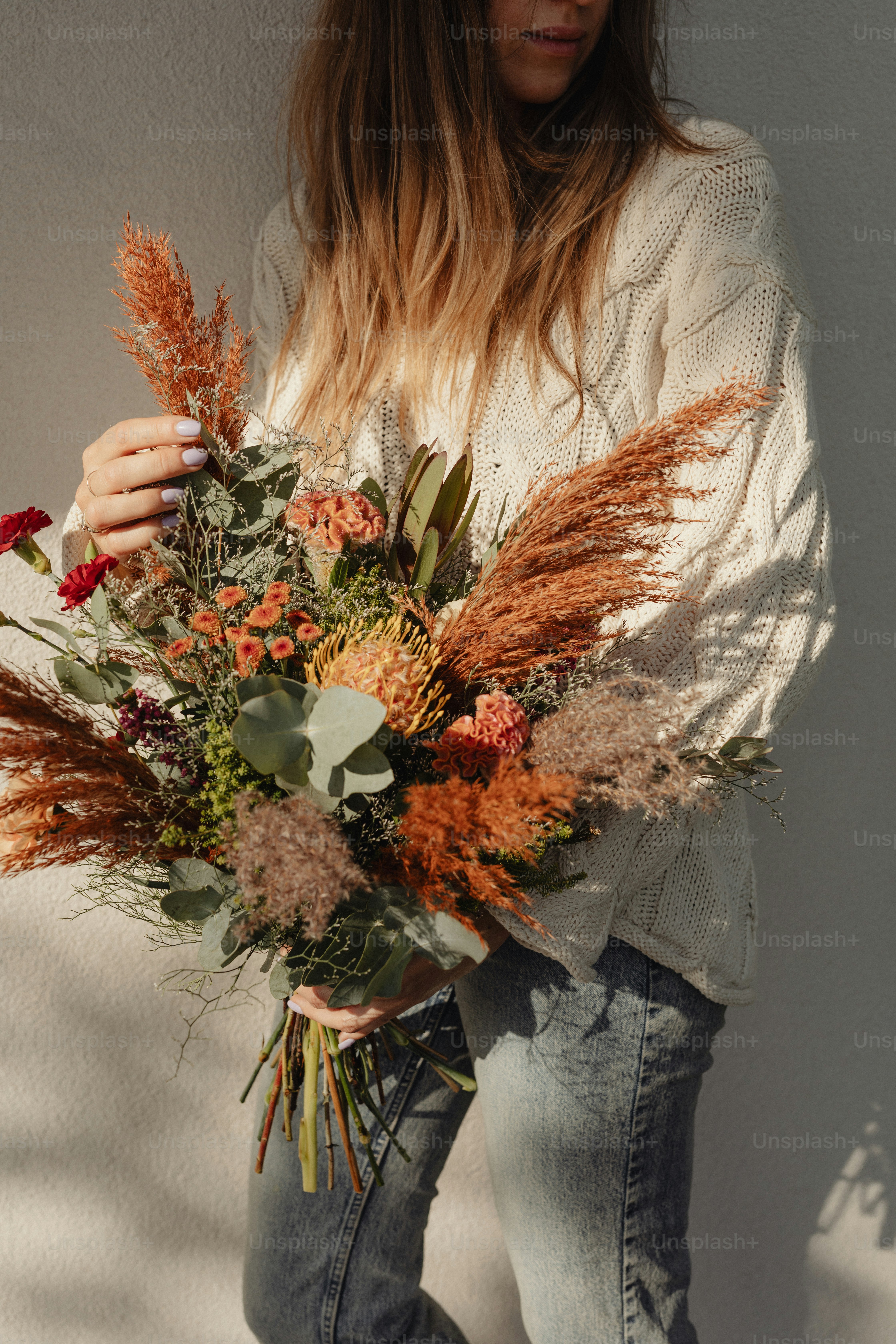 una donna che tiene un mazzo di fiori tra le mani