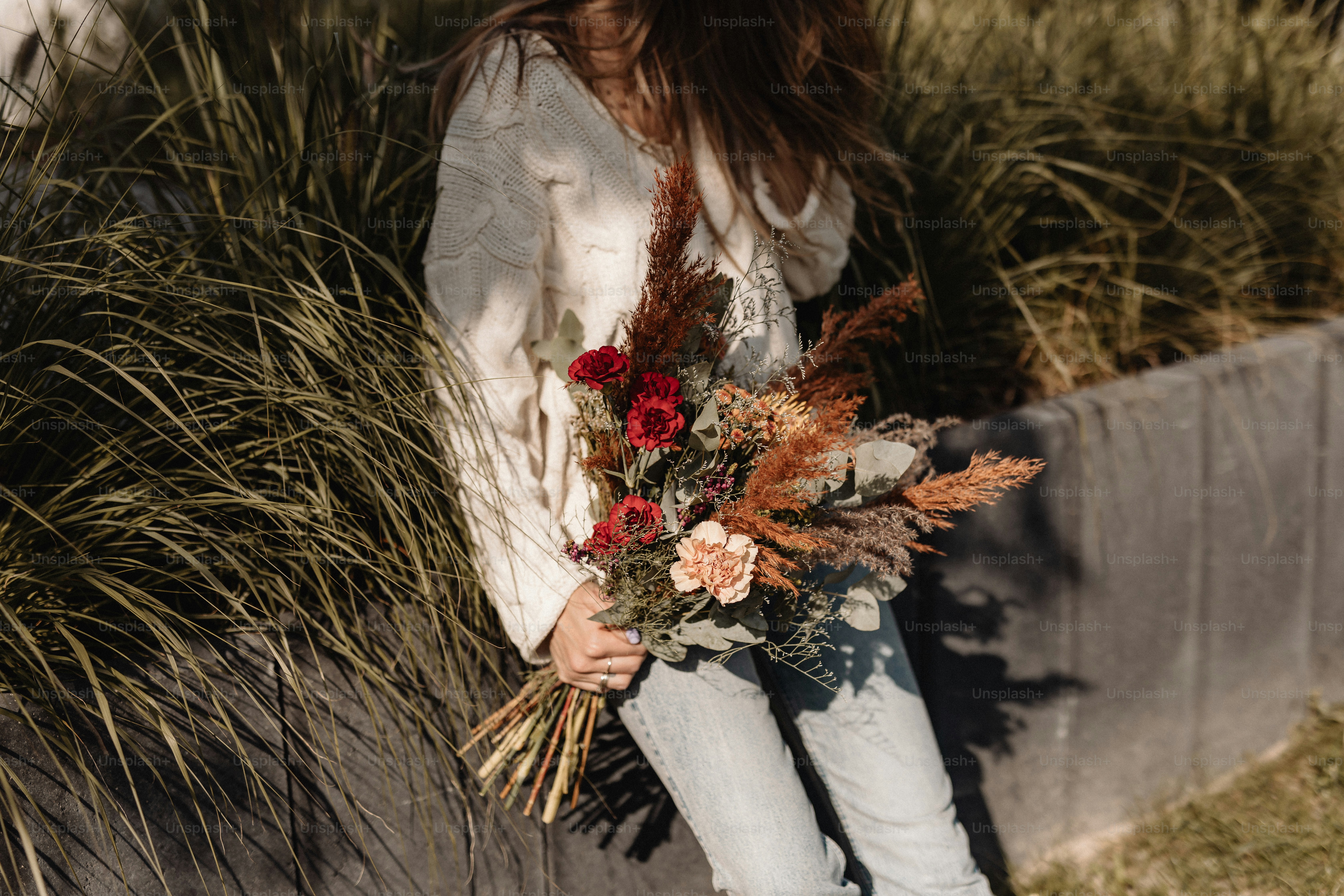una donna che tiene un mazzo di fiori tra le mani