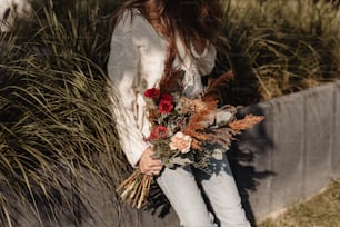 a woman holding a bouquet of flowers in her hands