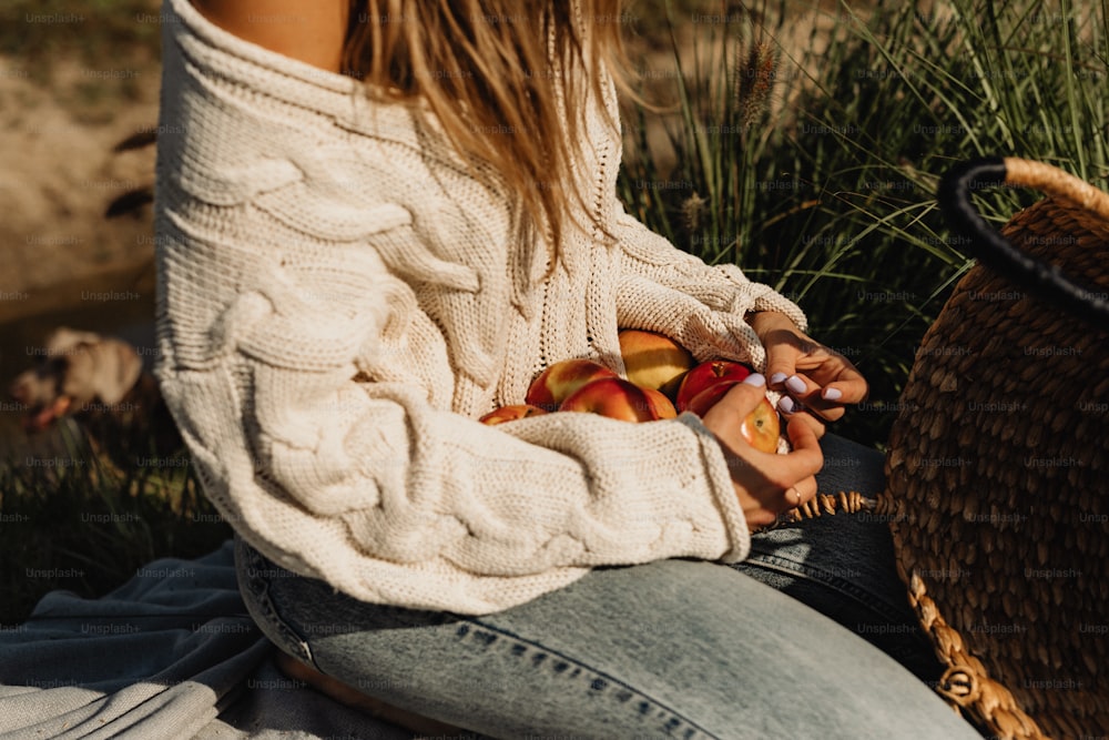 Une femme assise par terre avec une corbeille de fruits