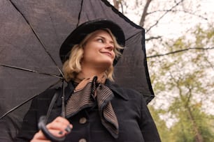 a woman wearing a hat and holding an umbrella