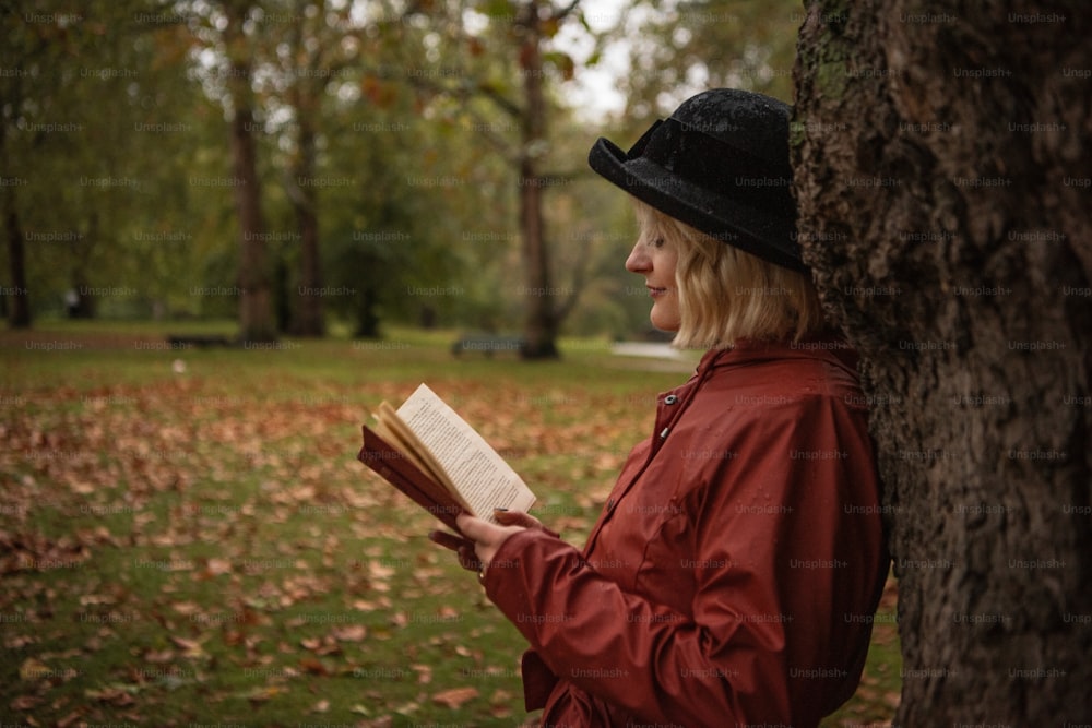 a woman in a hat is reading a book