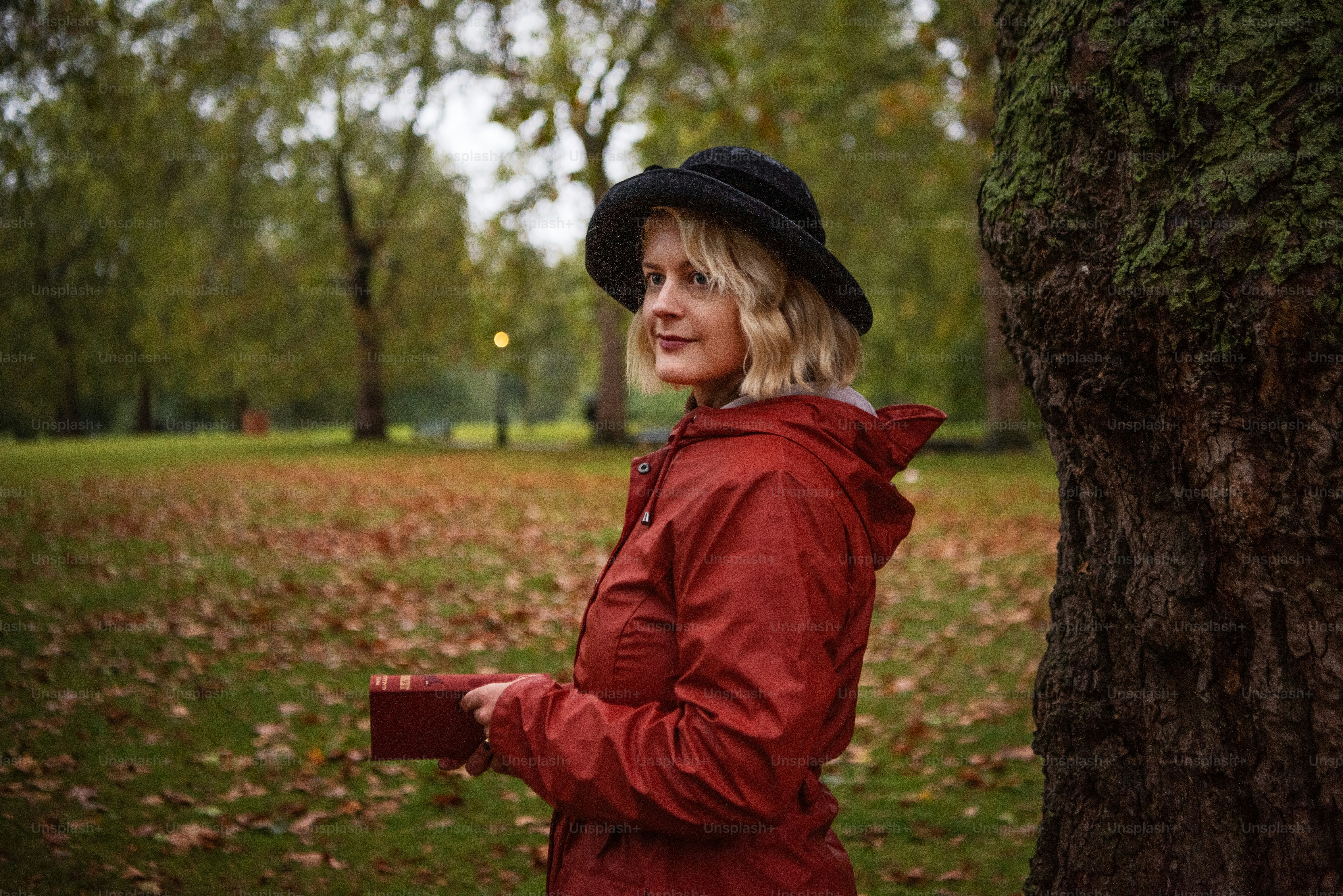 A woman standing next to a tree in a park photo – Lifestyle Image on ...