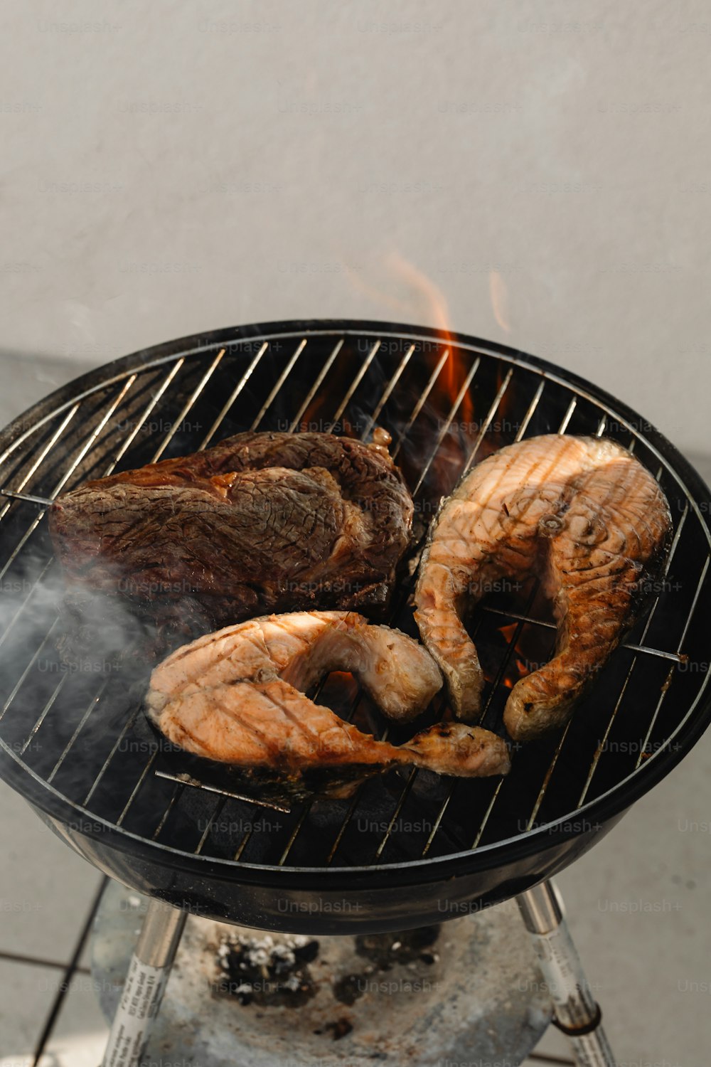una griglia barbecue con carne e verdure che cucinano su di esso