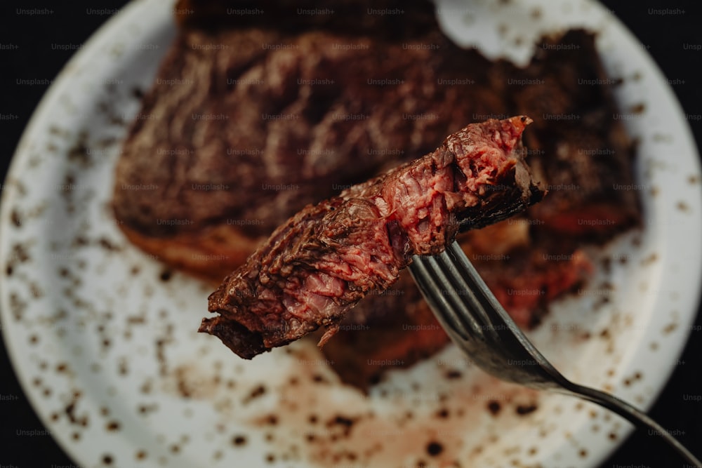 ein Stück Steak auf einem Teller mit einer Gabel