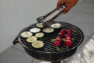 a person is grilling vegetables on a grill