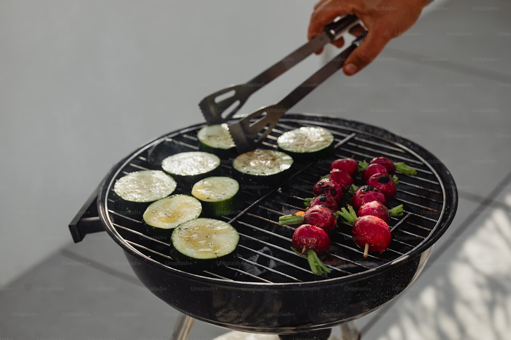 a person is grilling vegetables on a grill