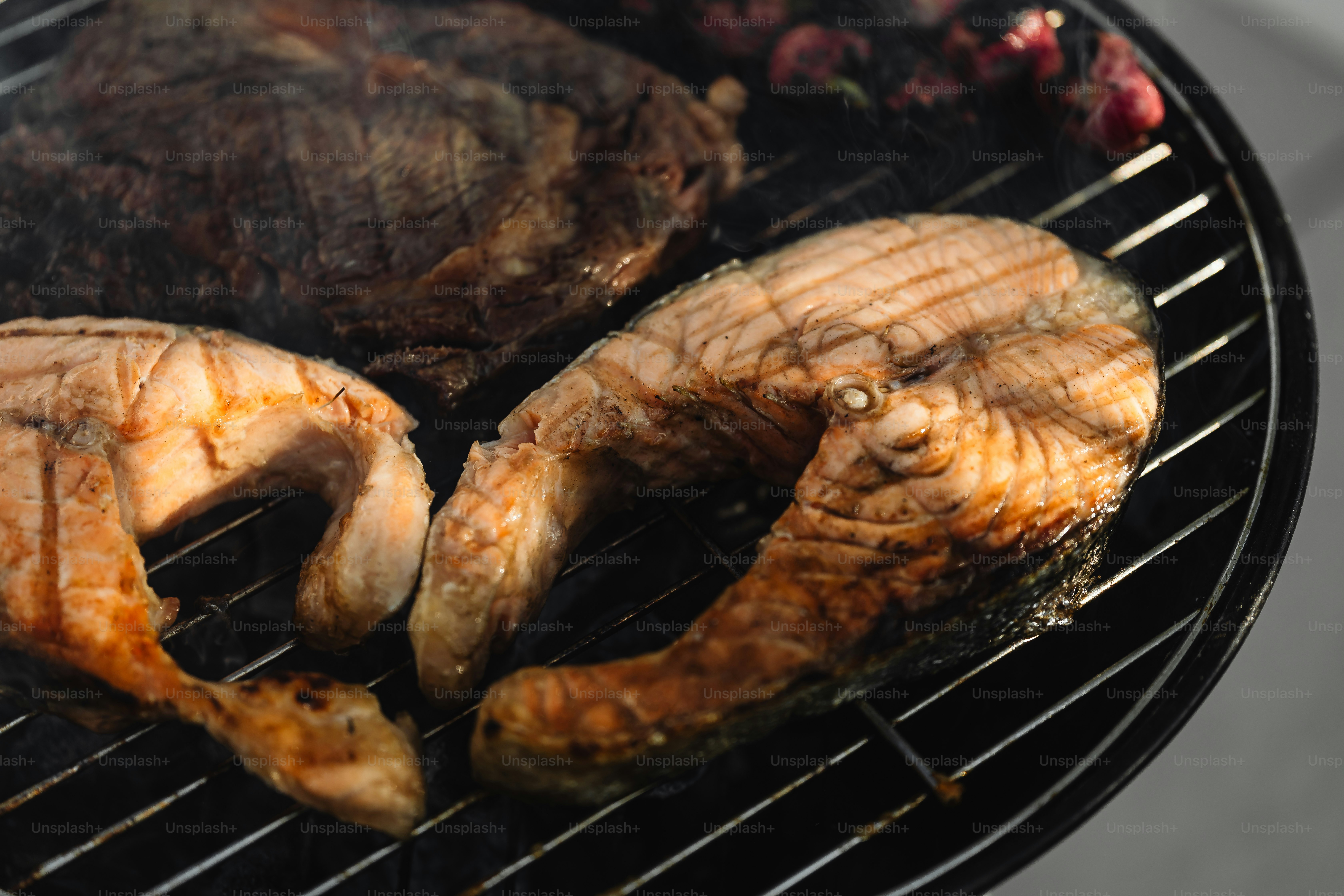 two pieces of meat cooking on a grill