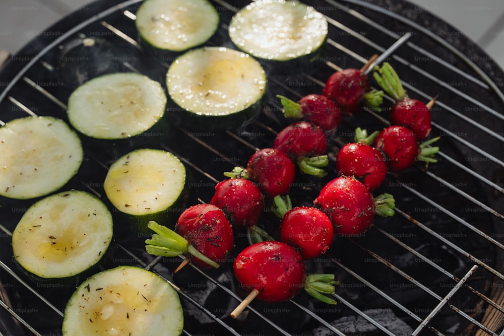 strawberries and cucumbers are being grilled on a grill