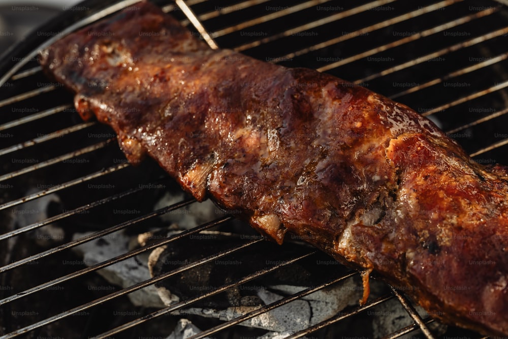 a piece of meat is cooking on a grill