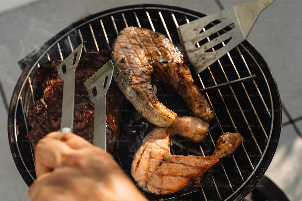 a person is grilling some meat on a grill