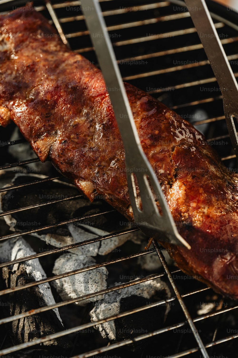 a piece of meat is being cooked on a grill