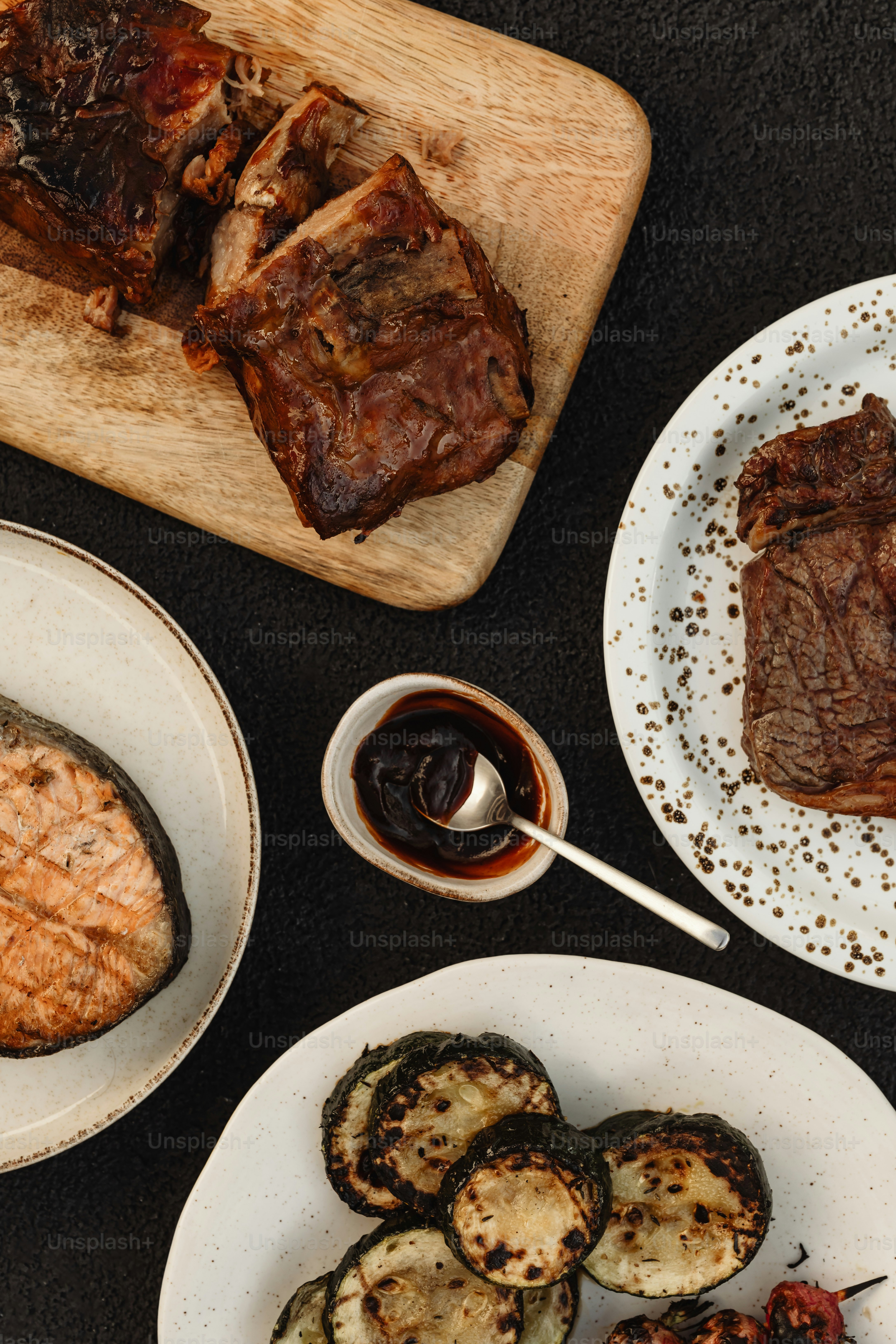 a table topped with plates of food next to a cutting board