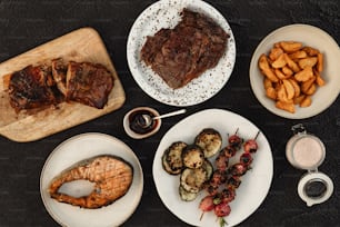 a table topped with plates of food next to a cutting board