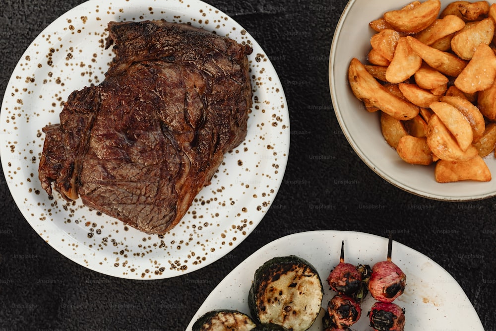 a table topped with plates of food and meat