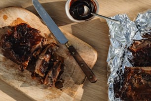 a wooden cutting board topped with meat next to a knife