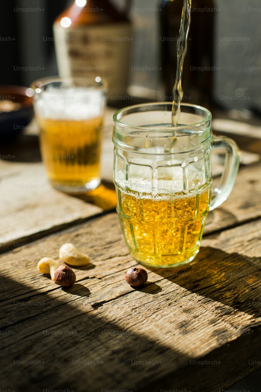a glass of beer being poured into a mug