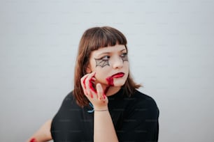 Una mujer con maquillaje en la cara sosteniendo un teléfono celular