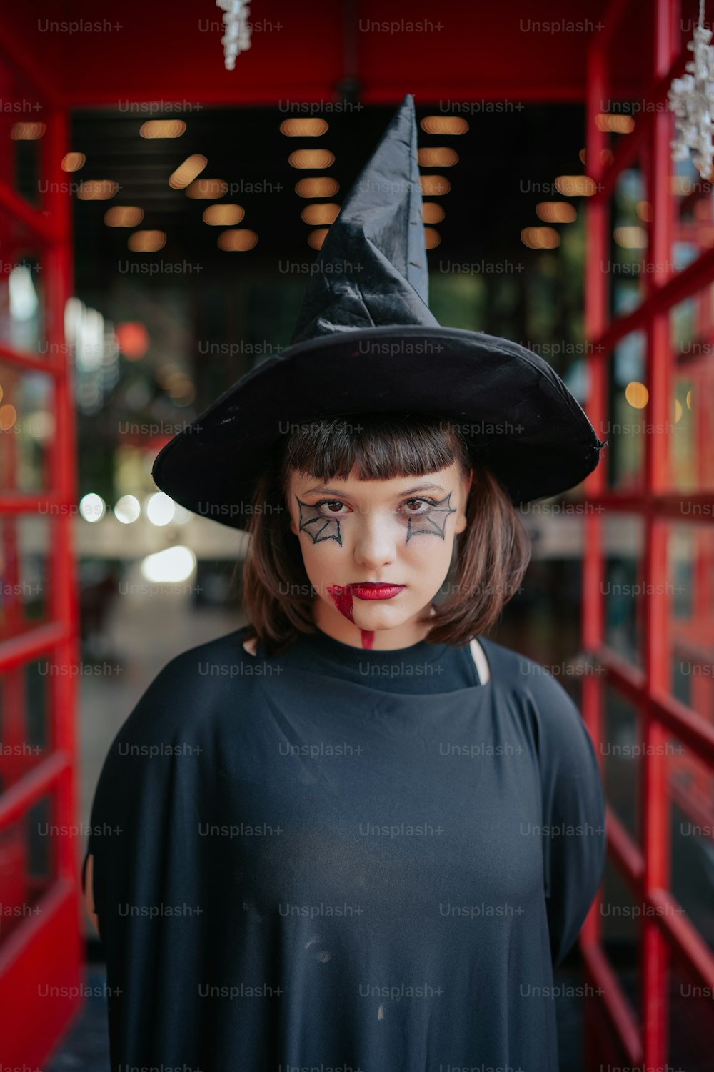 a woman wearing a witches hat and makeup