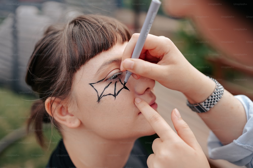 a woman with a spider drawn on her face