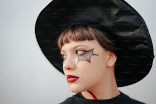 une femme portant un chapeau noir avec une araignée dessus