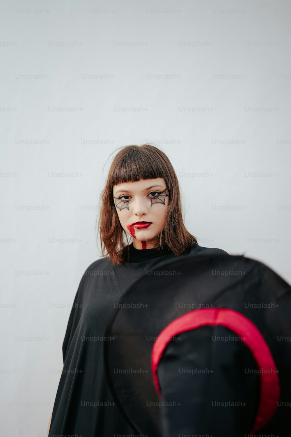 uma mulher em uma capa preta com detalhes vermelhos