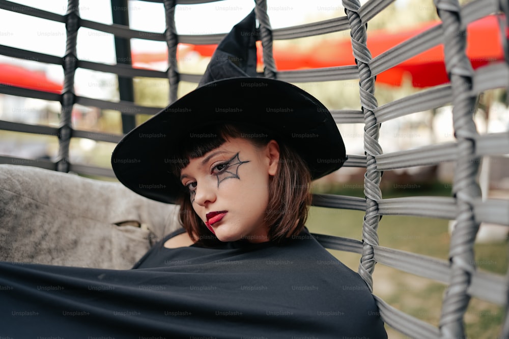 a woman in a witches costume laying on a hammock