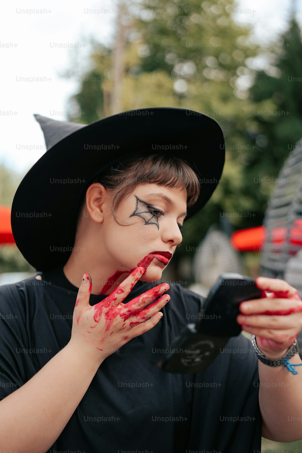 a young boy dressed as a witch using a cell phone