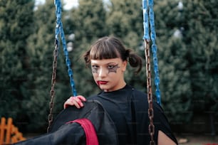 a woman in a black dress on a swing