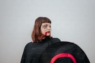 a woman with makeup on her face standing next to a backpack