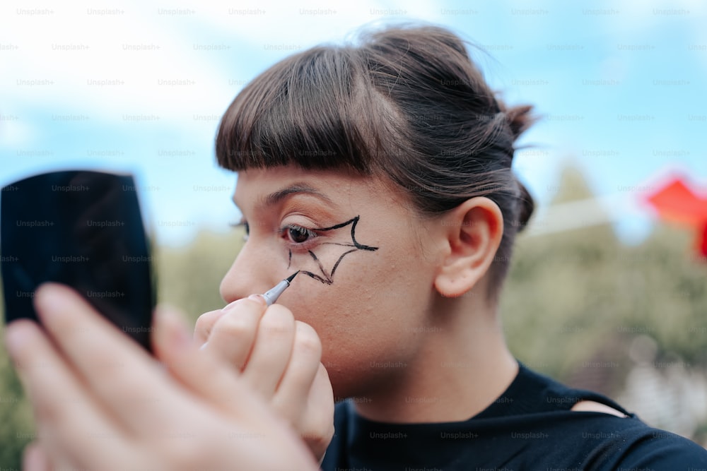 a girl with a face painted on her face using a cell phone
