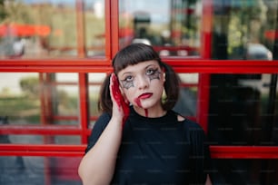 Una mujer con pintura facial sosteniendo un teléfono celular