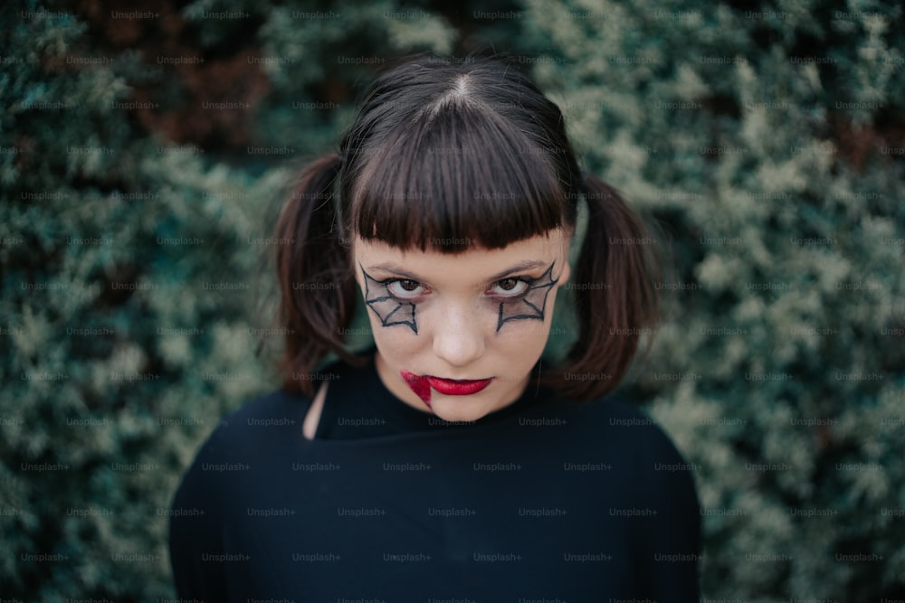 A woman with black and white makeup holding her hands to her face photo –  Halloween makeup Image on Unsplash