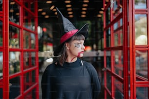 uma mulher usando um chapéu de bruxas e maquiagem