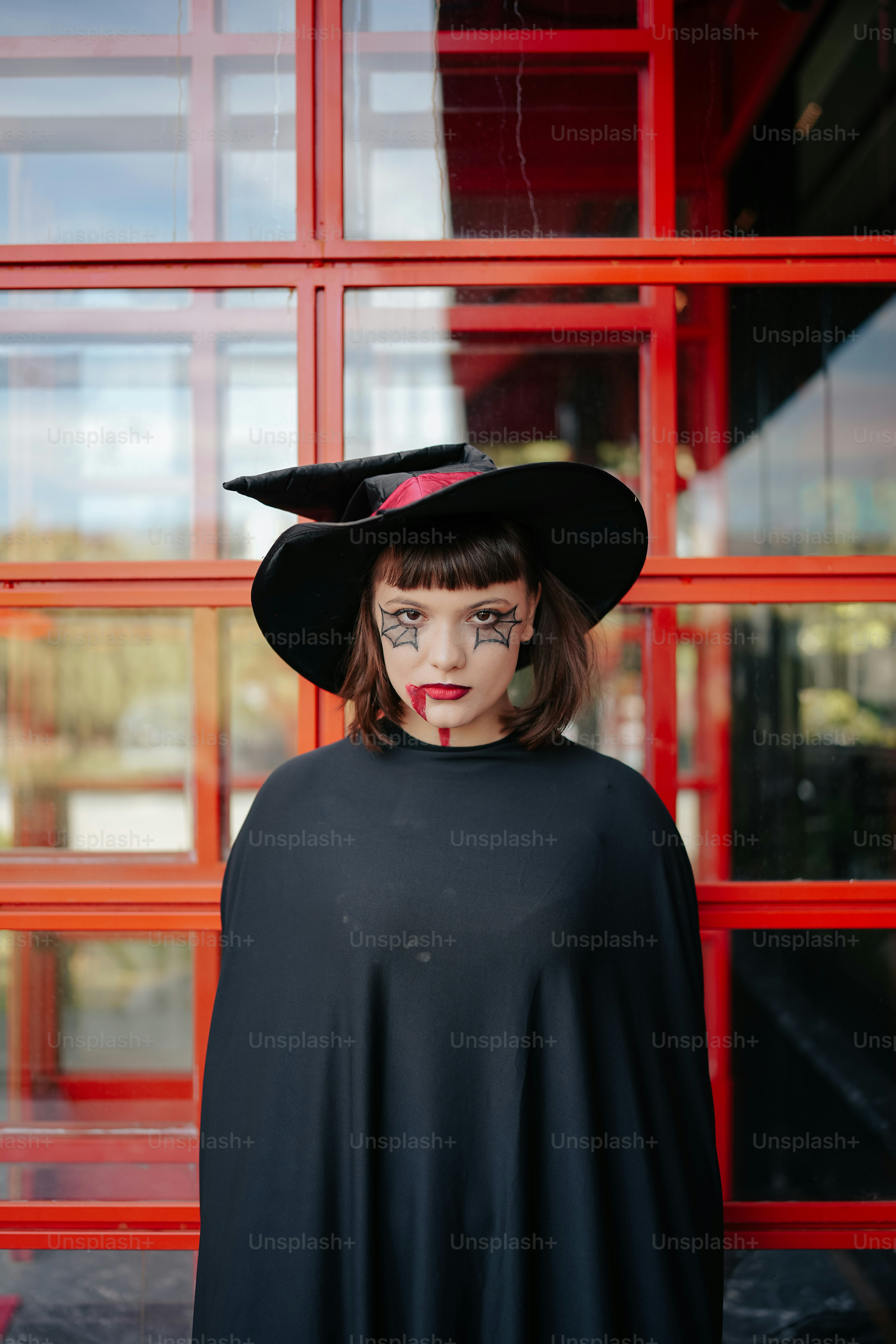 seorang wanita mengenakan jubah hitam dan topi hitam