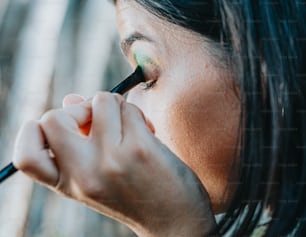 a woman is holding a pencil to her eye