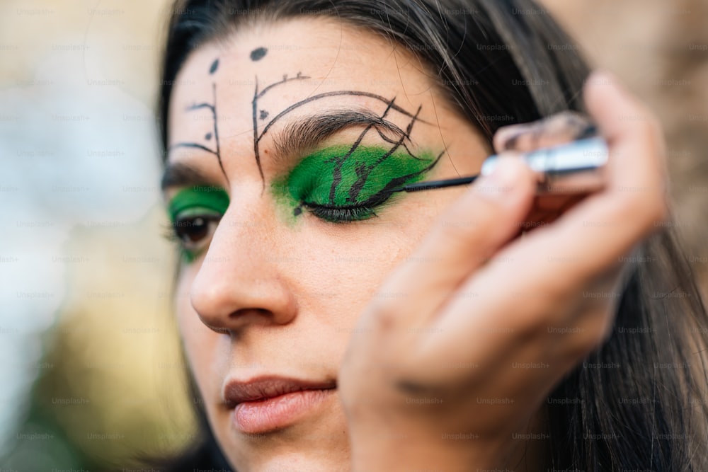 Una mujer con maquillaje verde y delineador de ojos verde