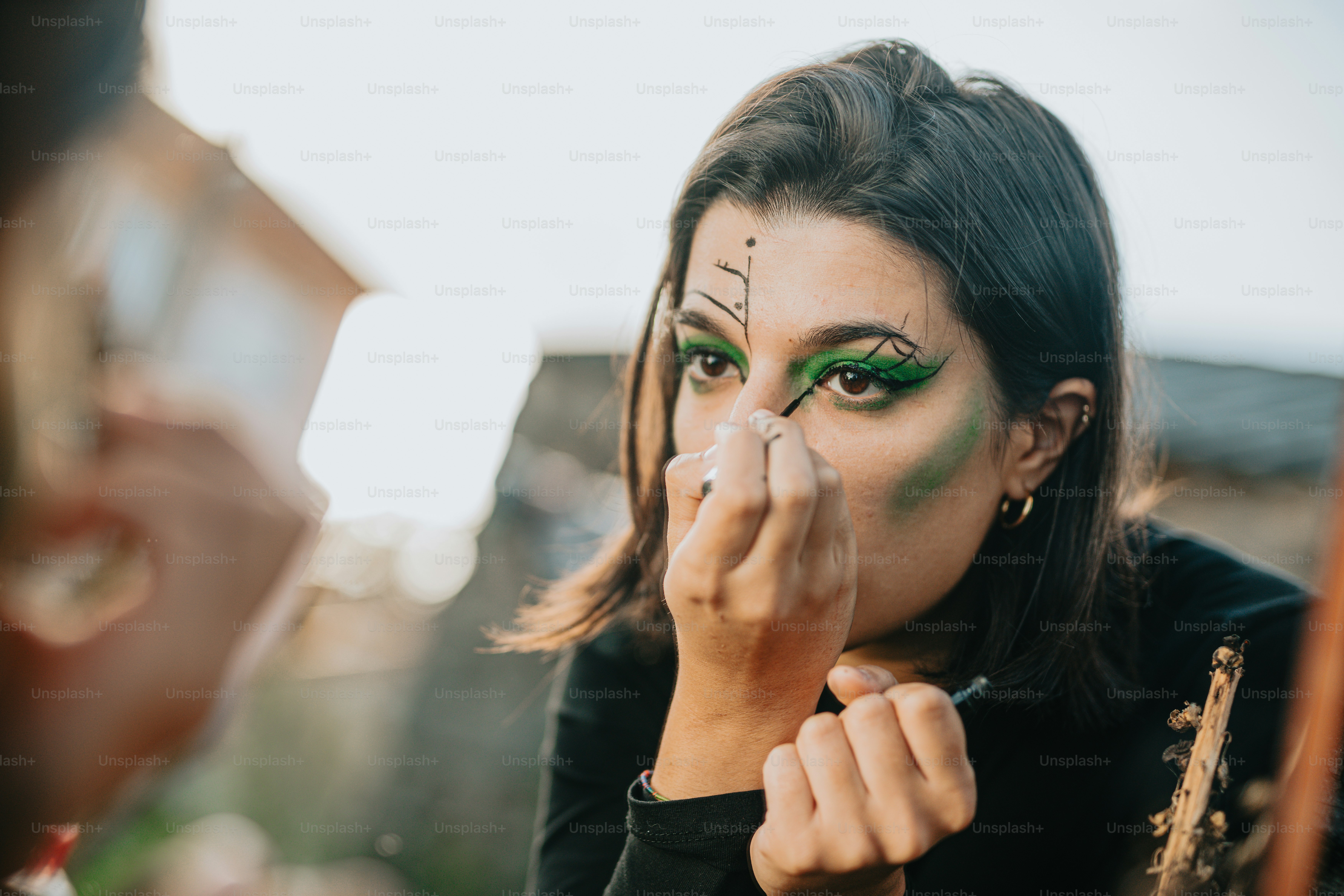 Una donna con il trucco verde si sta truccando