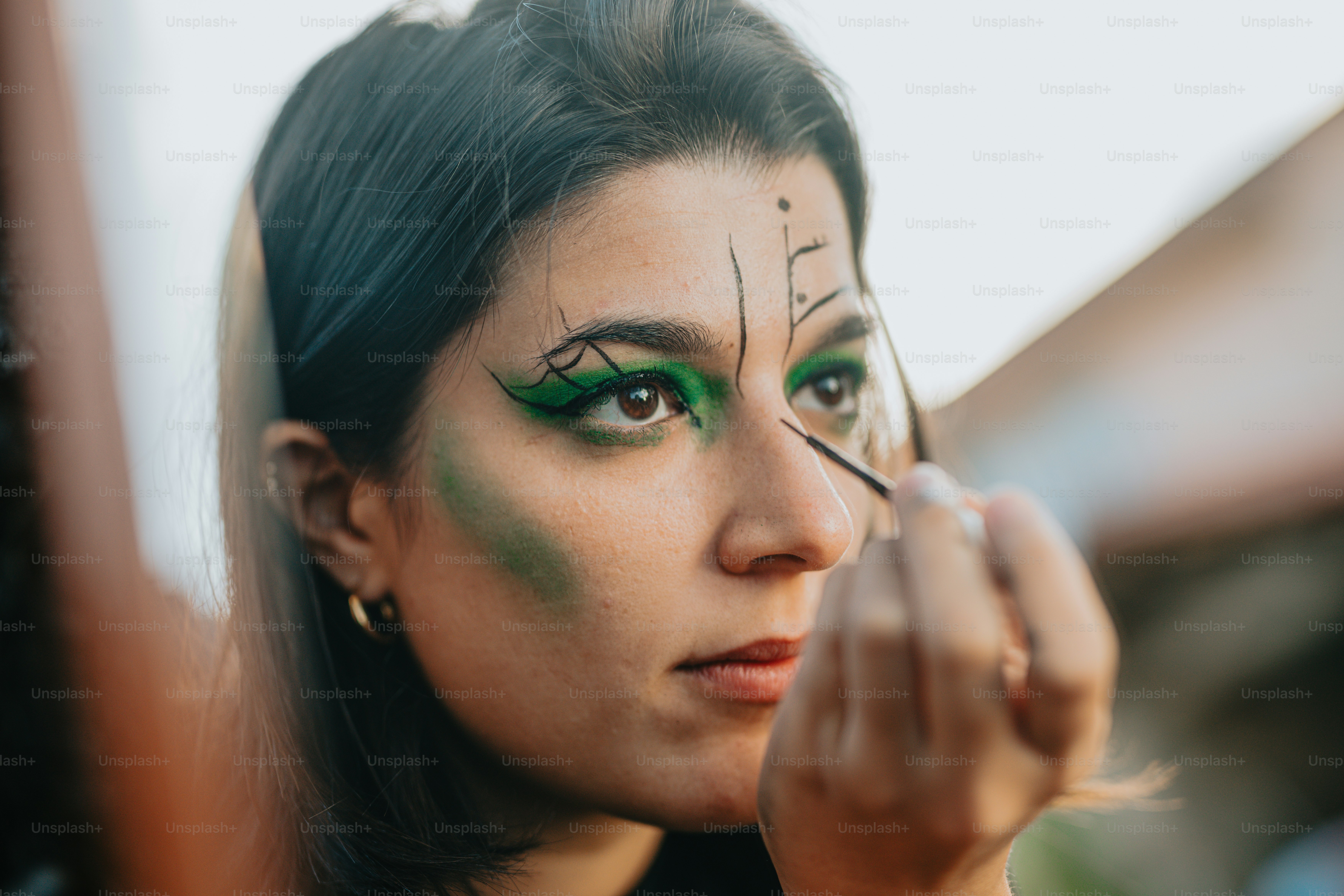Una donna con un trucco verde sul suo viso