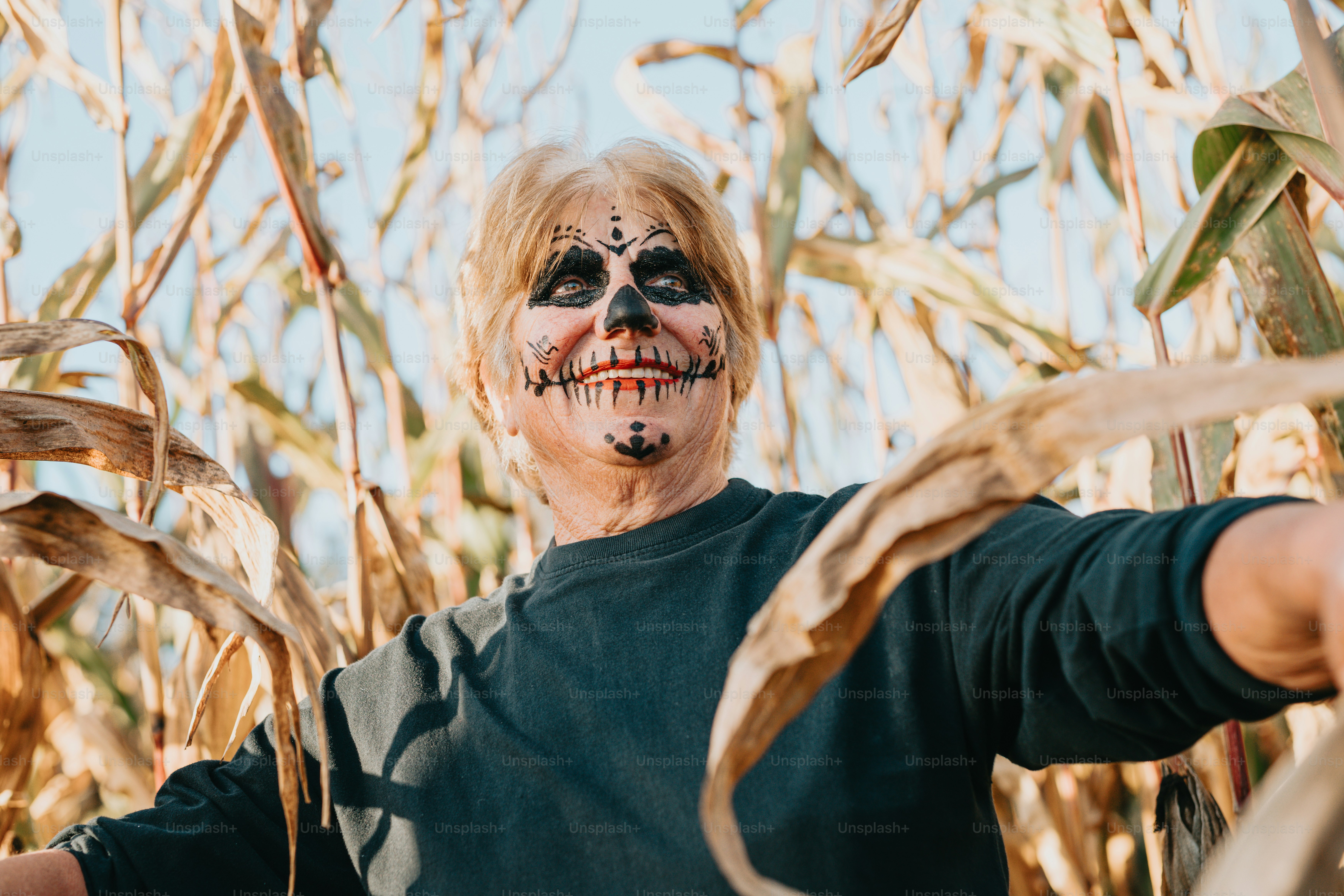 Un uomo con la faccia dipinta in piedi in un campo di grano