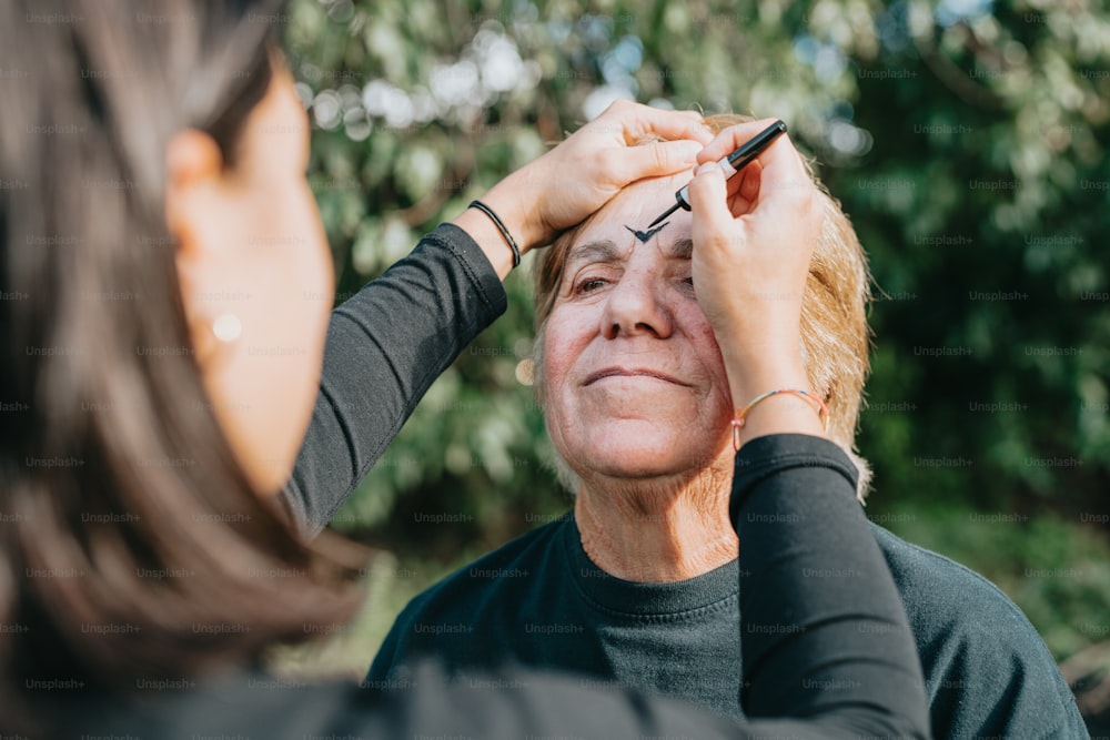 a woman getting her eyebrows done by an older woman