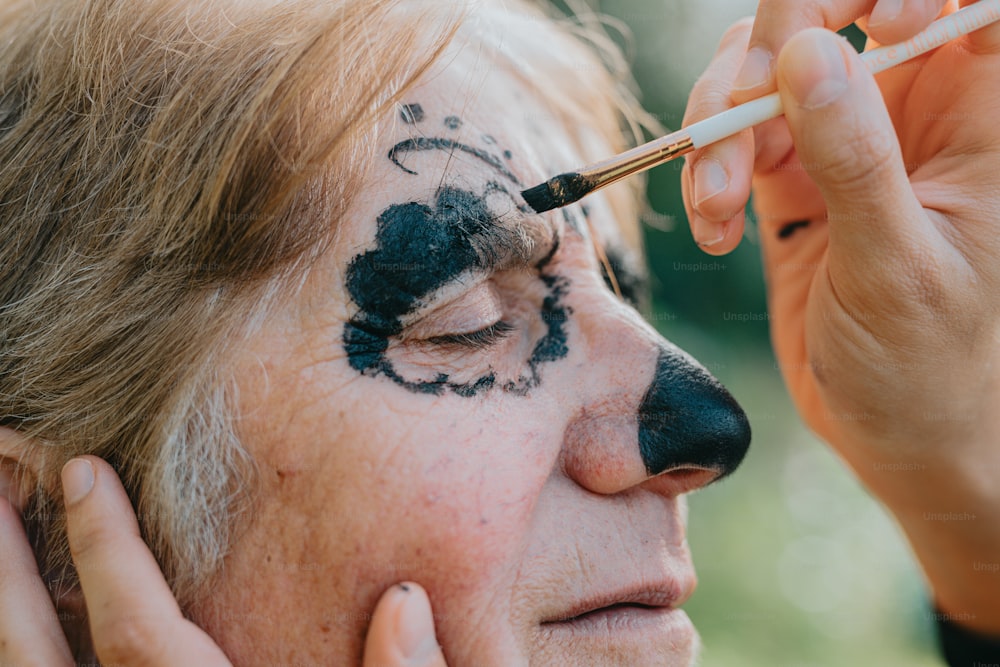 a woman with black face paint on her face