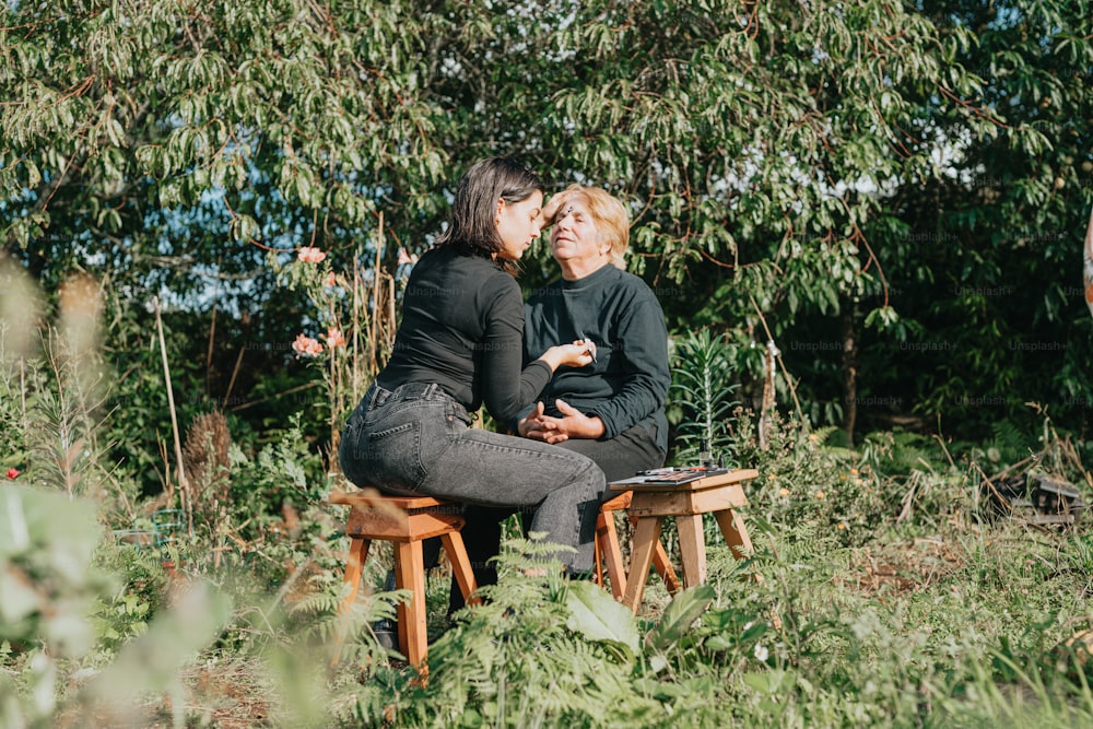 Un par de mujeres sentadas encima de un banco de madera