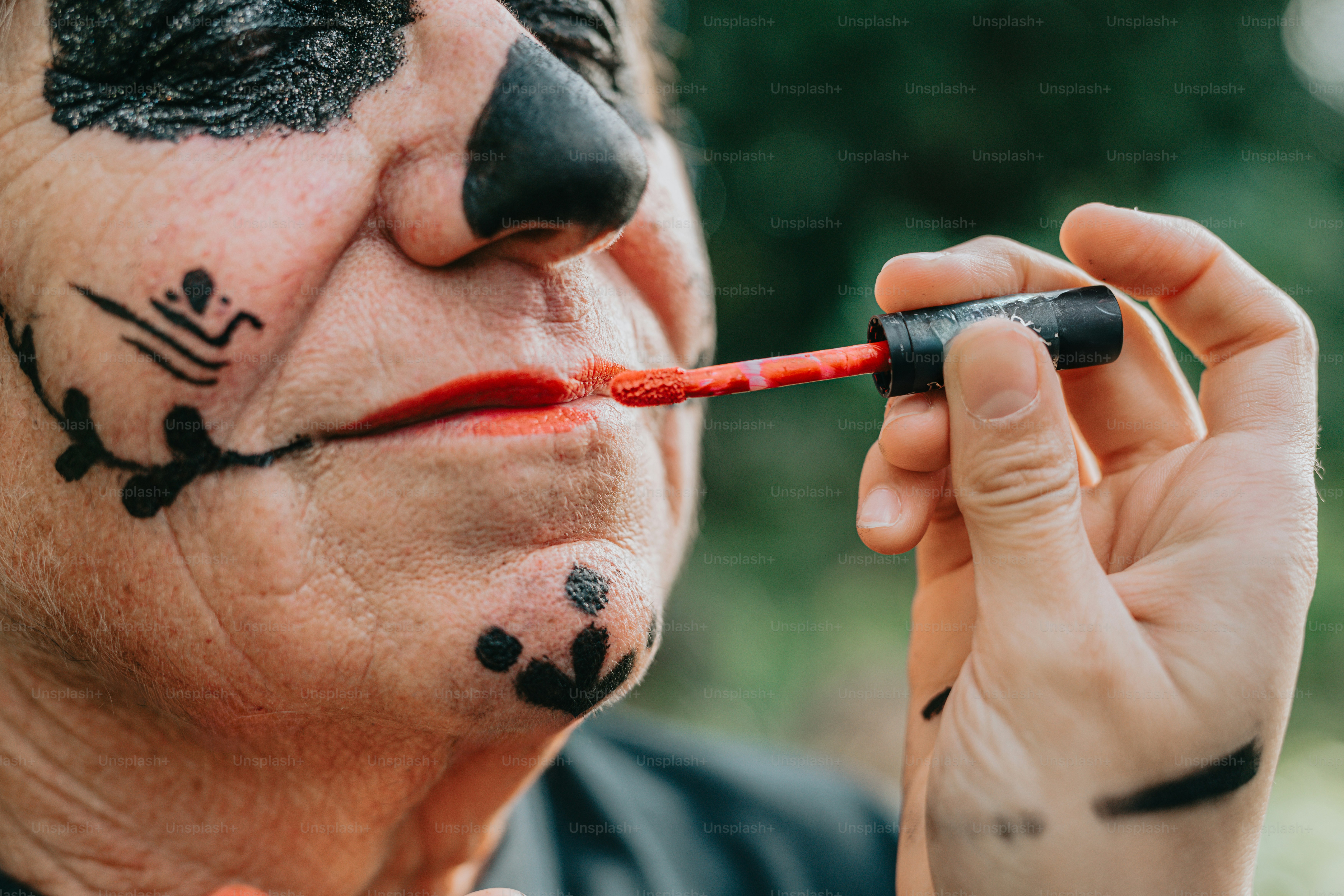 un homme avec de la peinture faciale sur le visage et le nez