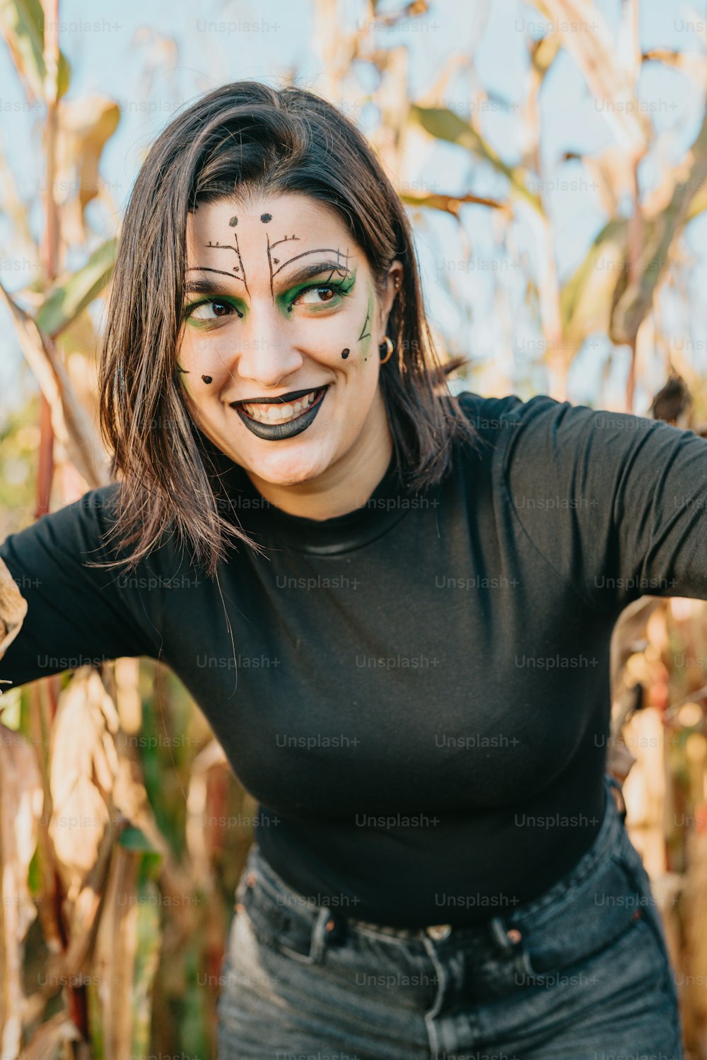 a woman with painted face standing in a corn field